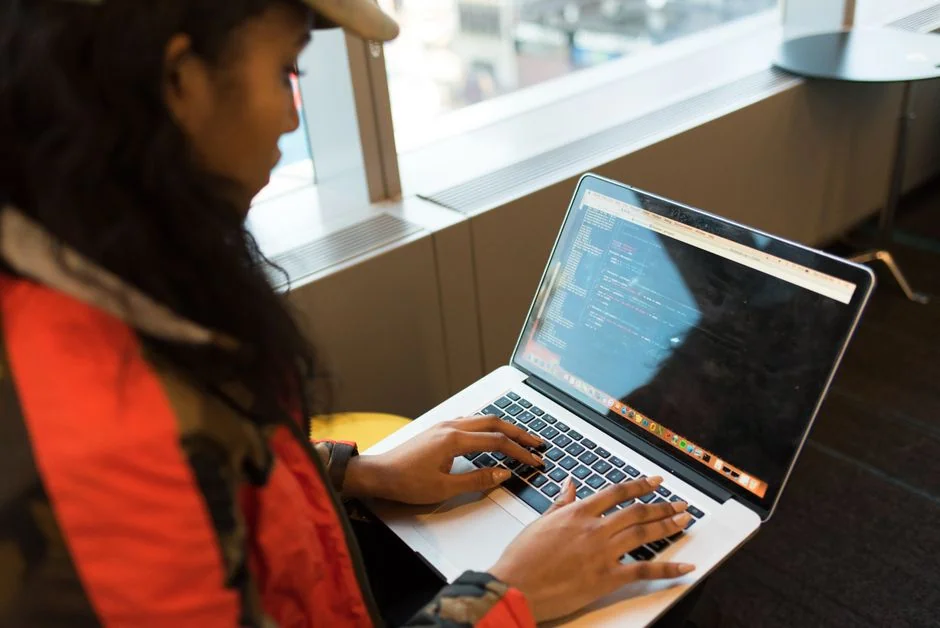 Close-up of hands interacting with a shopping website on a laptop screen indoors.